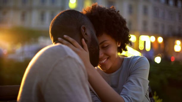 Petty woman tenderly stroking boyfriends face, love expression, nuzzling on date
